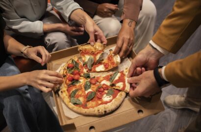 close-up-hands-holding-pizza-slices